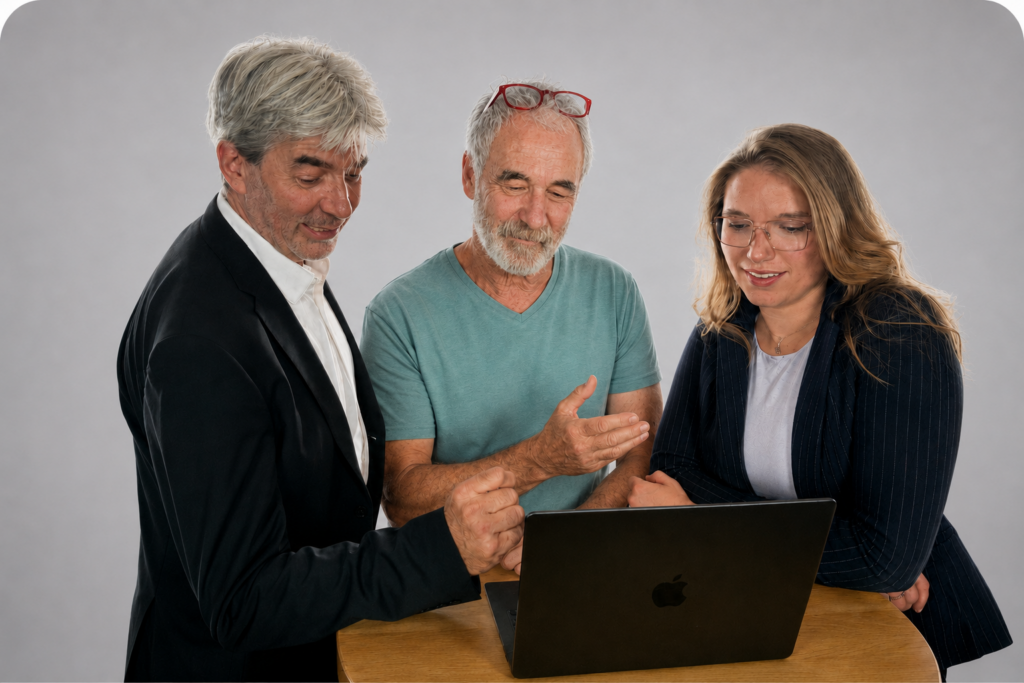 Drei Teammitglieder arbeiten gemeinsam am Laptop.